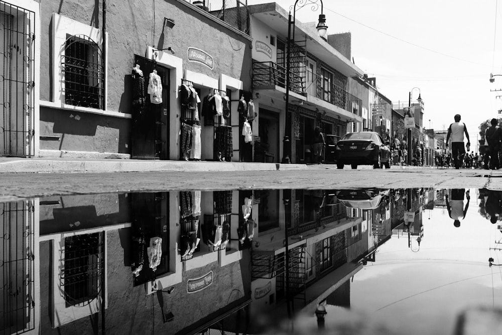 grayscale photo of people walking at the sidewalk