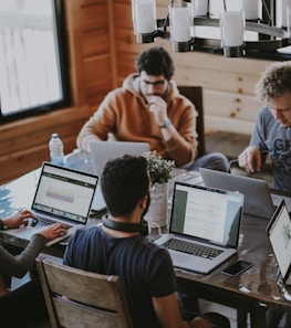 men sitting in front of their laptop computer