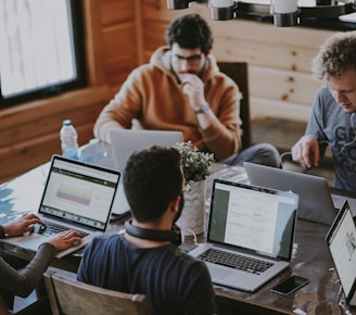 men sitting in front of their laptop computer