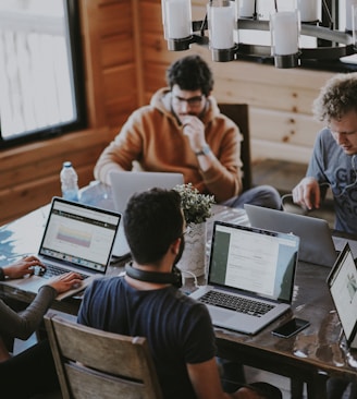 men sitting in front of their laptop computer