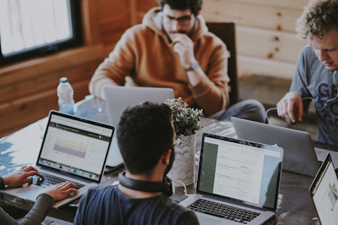 men sitting in front of their laptop computer