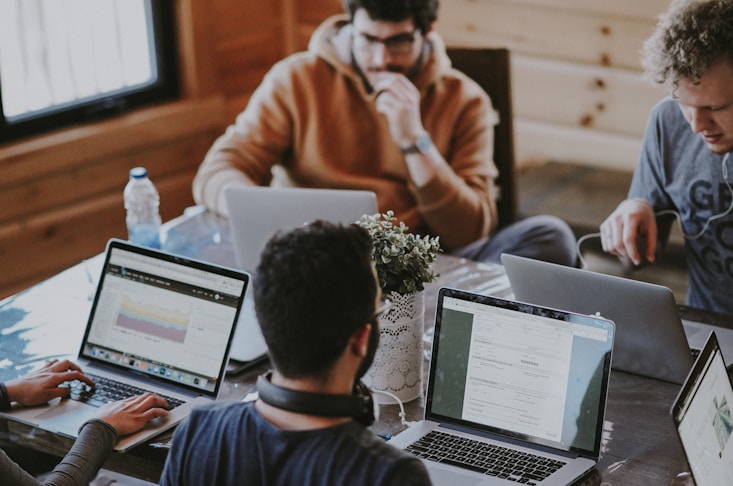 men sitting in front of their laptop computer