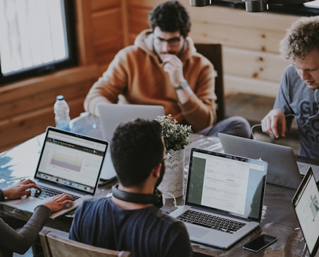 men sitting in front of their laptop computer