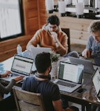 men sitting in front of their laptop computer