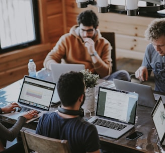 men sitting in front of their laptop computer