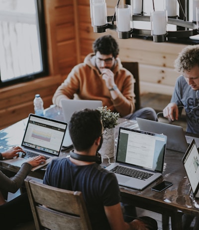 men sitting in front of their laptop computer