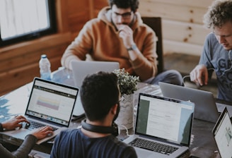 men sitting in front of their laptop computer