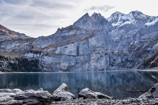 body of water near mountain during daytime in Oeschinen Lake Switzerland