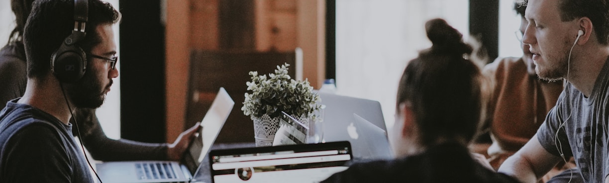 selective focus photography of people sits in front of table inside room