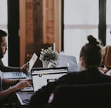 selective focus photography of people sits in front of table inside room