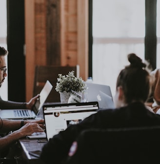 selective focus photography of people sits in front of table inside room