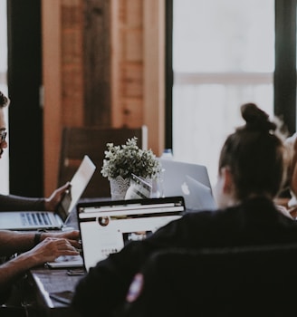 selective focus photography of people sits in front of table inside room