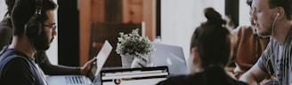 selective focus photography of people sits in front of table inside room