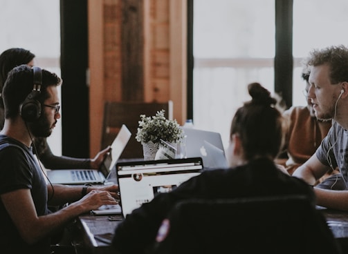 selective focus photography of people sits in front of table inside room