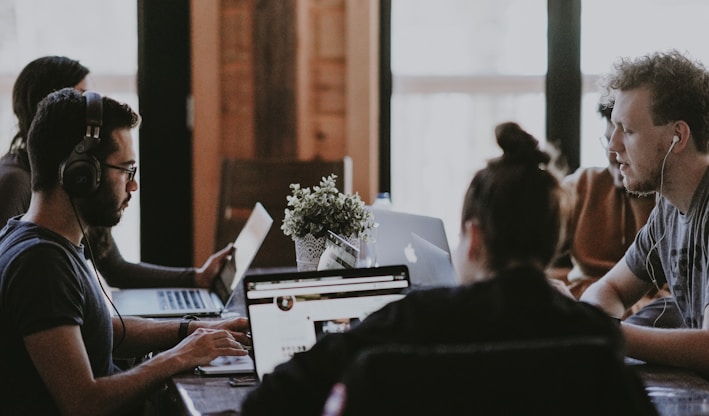 selective focus photography of people sits in front of table inside room