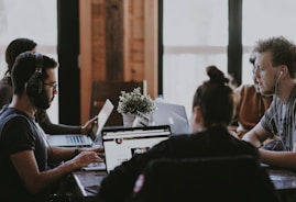 selective focus photography of people sits in front of table inside room
