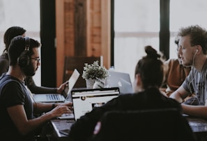 selective focus photography of people sits in front of table inside room