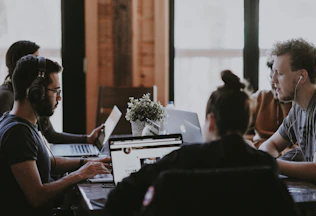 selective focus photography of people sits in front of table inside room