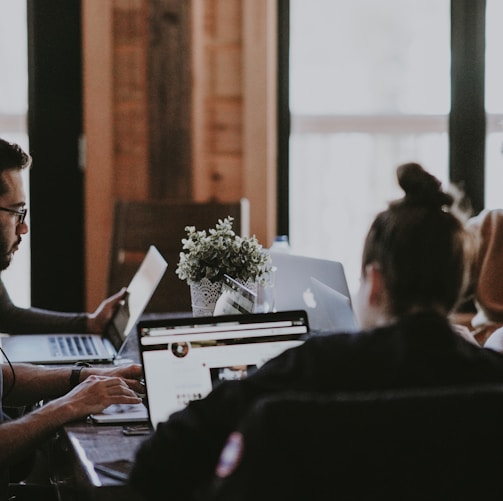 selective focus photography of people sits in front of table inside room