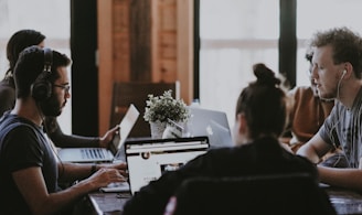 selective focus photography of people sits in front of table inside room