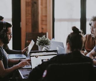 selective focus photography of people sits in front of table inside room