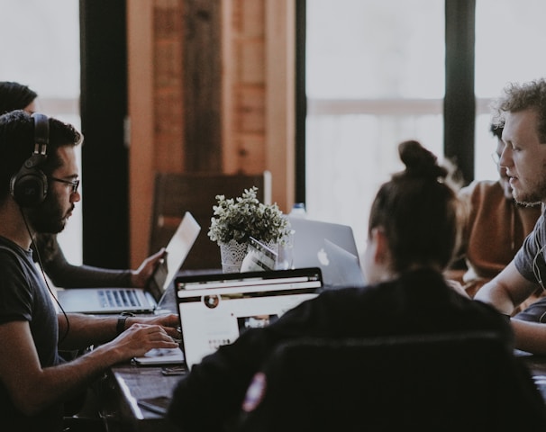 selective focus photography of people sits in front of table inside room