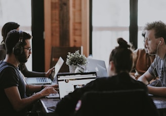 selective focus photography of people sits in front of table inside room