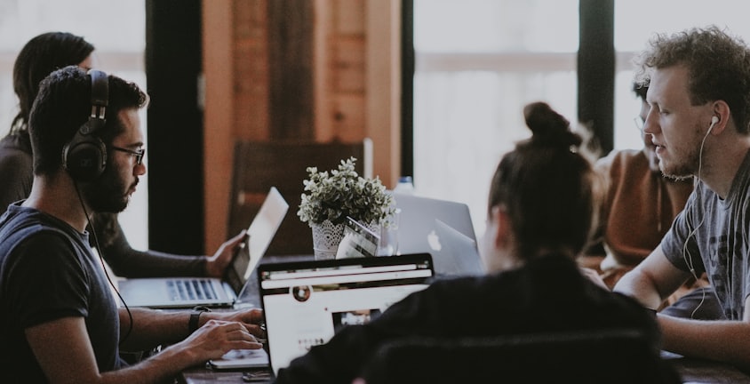 selective focus photography of people sits in front of table inside room