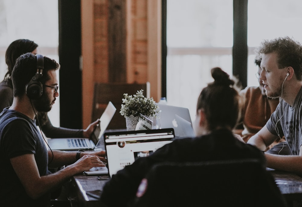 selective focus photography of people sits in front of table inside room