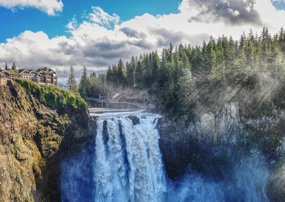 brown and white building beside waterfalls