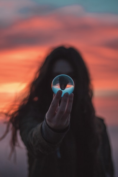 selective focus photography of woman holding crystal ball