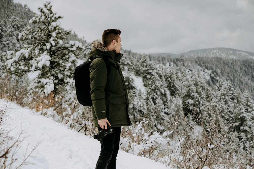 man standing on snow-covered land during daytime