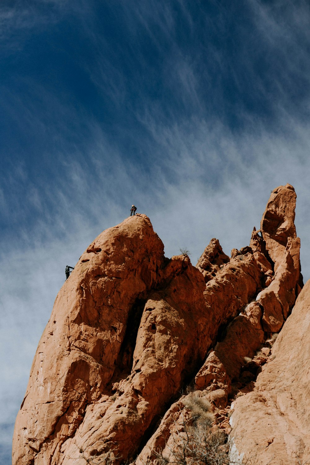 two person on rocky hill during daytime