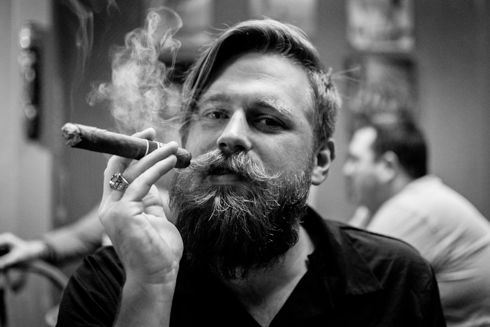 Fotografía de retrato en escala de grises de una persona fumando cigarros