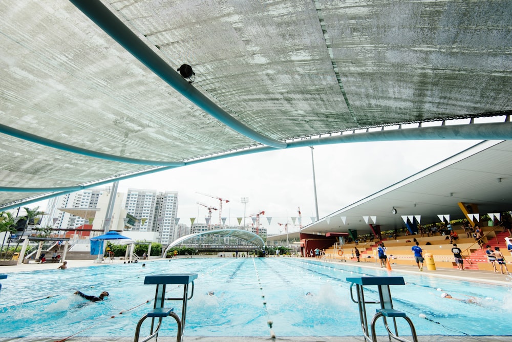 people gathering around in an olympic pool during day time