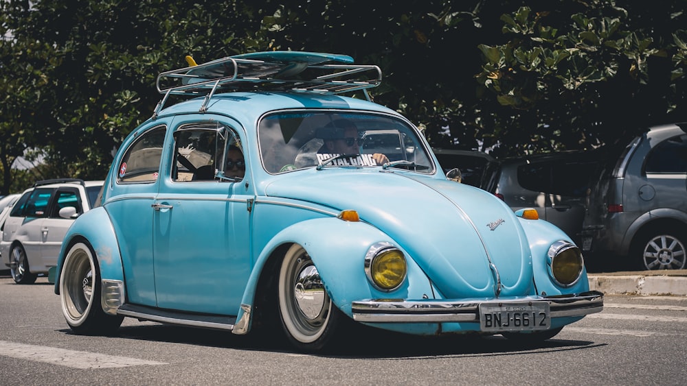 blue Volkswagen Beetle on road