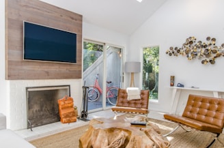 two tufted brown leather chairs in front of brown wood stump center table