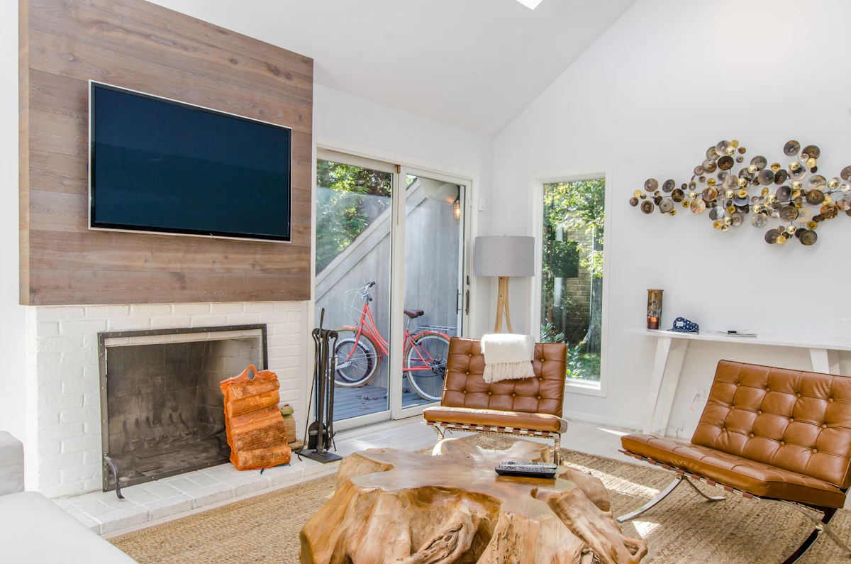 Converted loft living area after works, with leather chairs, timber panelling and a log burner