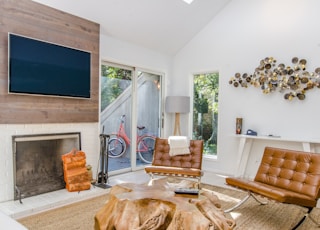 two tufted brown leather chairs in front of brown wood stump center table