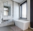 white ceramic bathtub near white framed window
