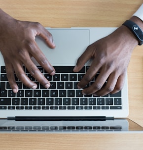 person's hand on MacBook near iPhone flat lay photography