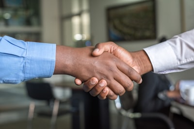 two people shaking hands sales teams background