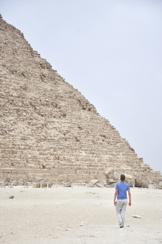 man standing near pyramid during daytime in Khufu Ship Egypt