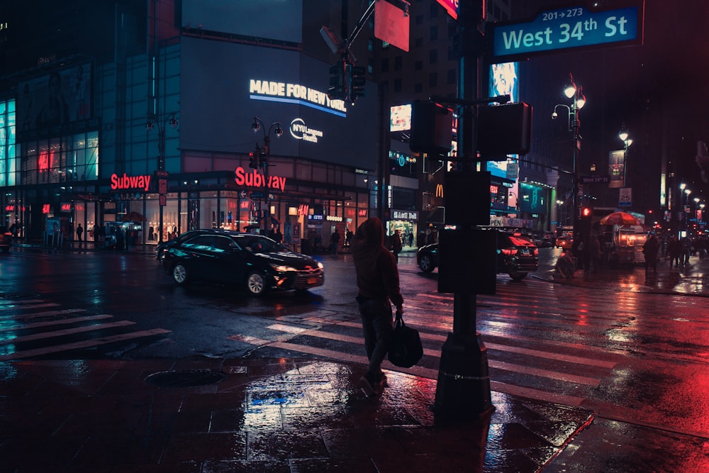 person standing beside traffic light during night