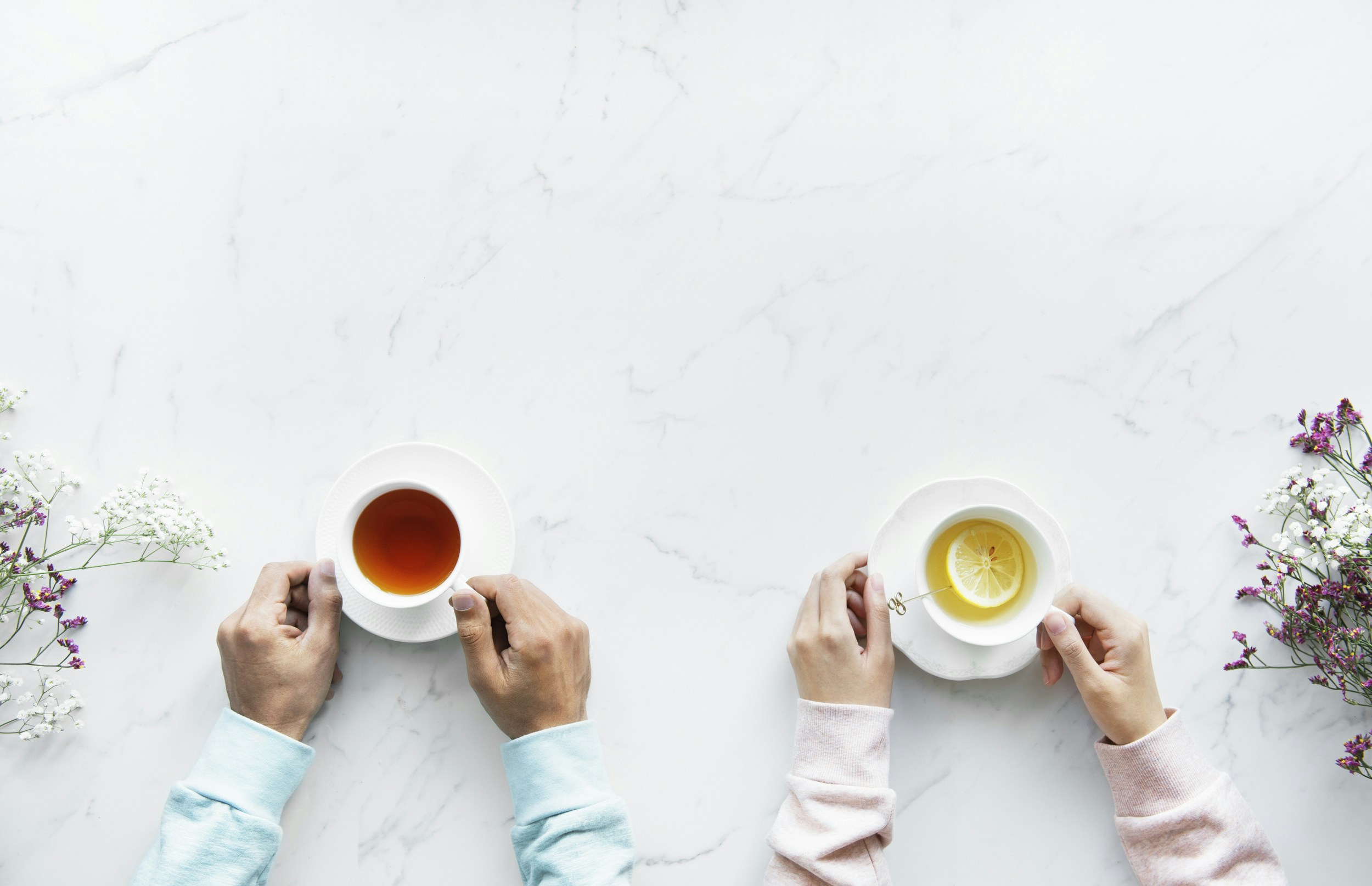 two person holding ceramic mugs