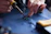 Close-up of a student soldering electronic components on a circuit board.