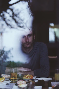 man sitting in front of table with sliced citrus fruit