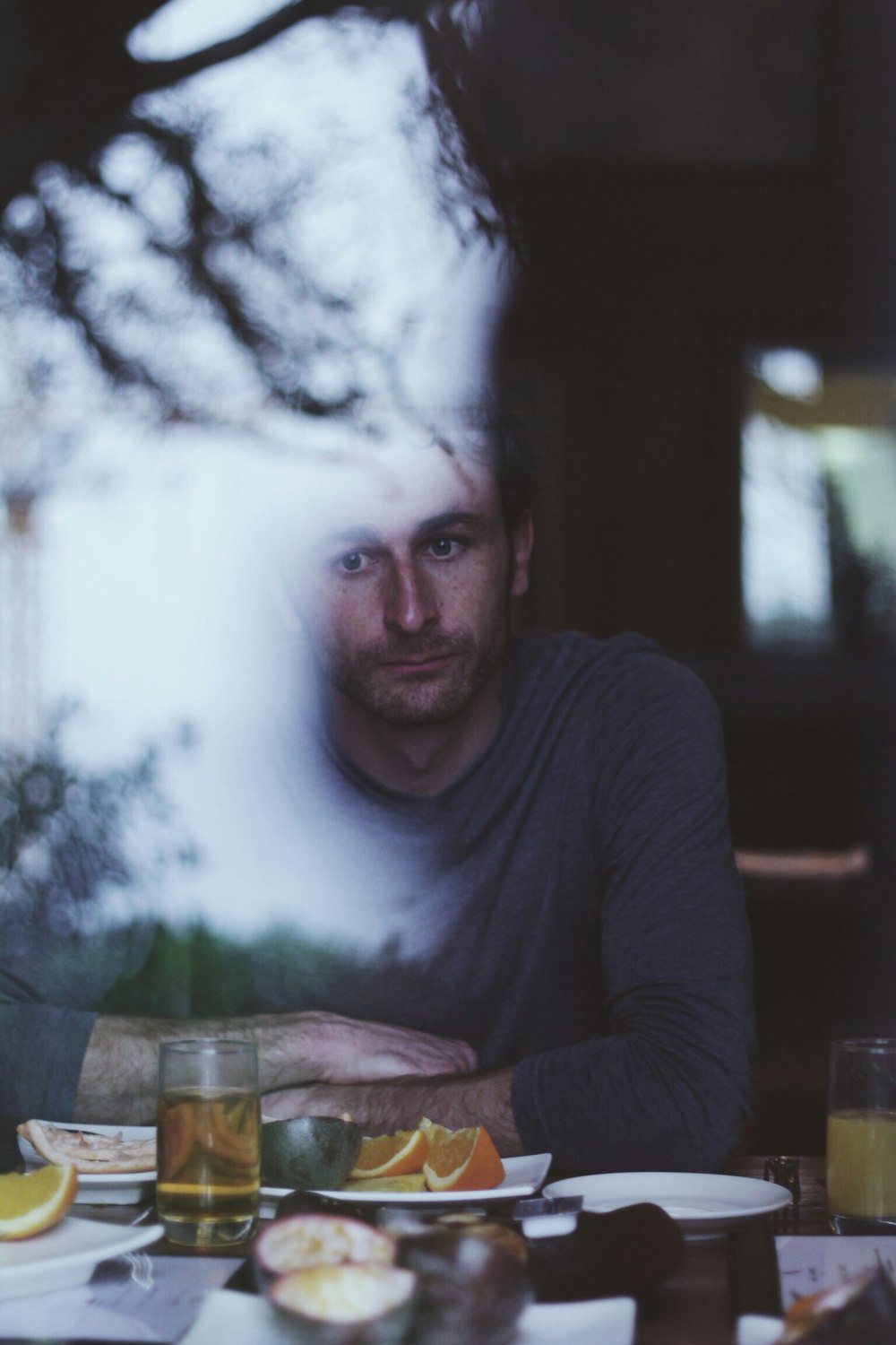 Homme assis devant une table avec des agrumes tranchés