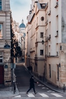 photography of person walking on sideway looking at leftside with buildings