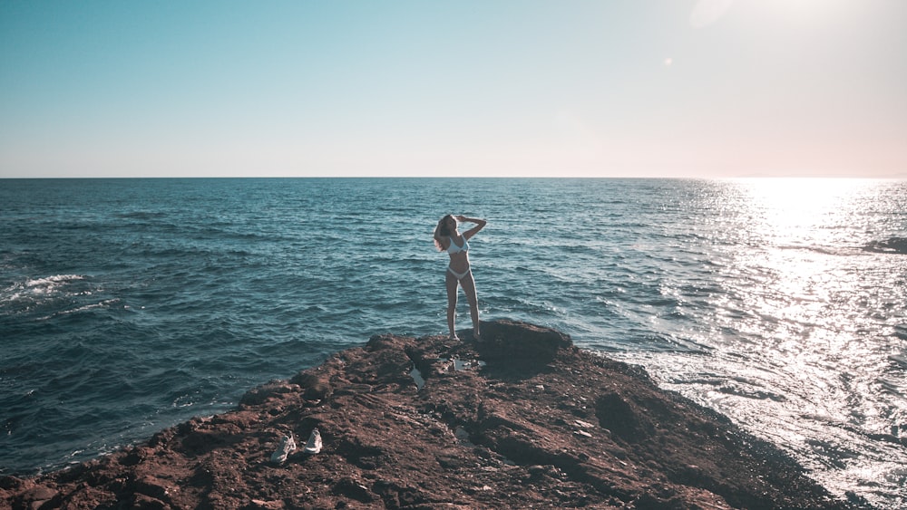 Frau auf einer Klippe neben dem Meer